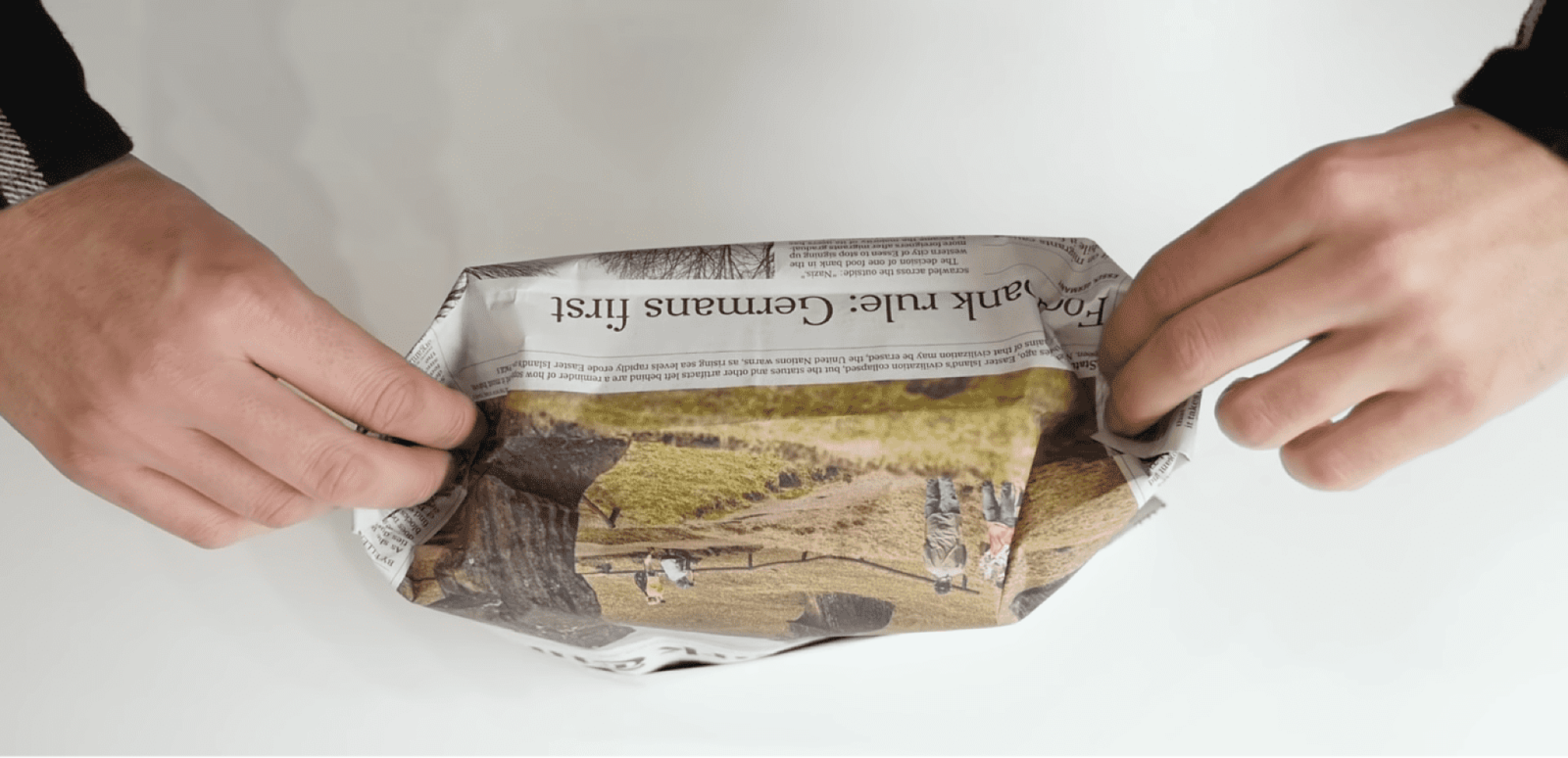 新聞紙を折る男性