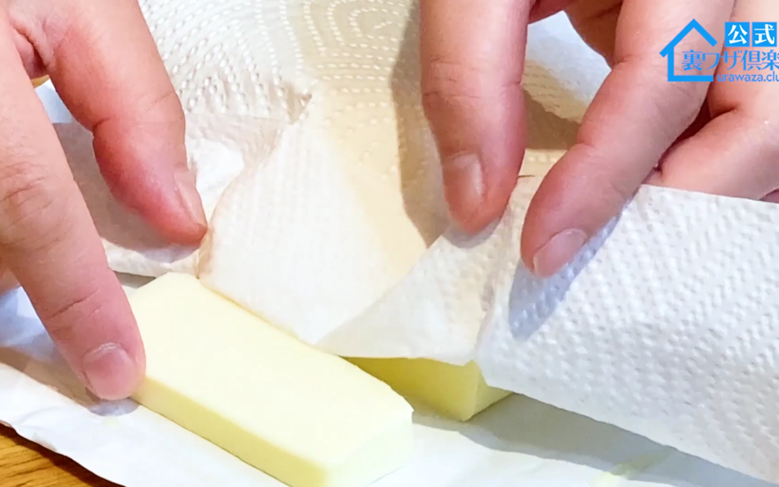 クッキングペーパーと包丁でバターを切る女性