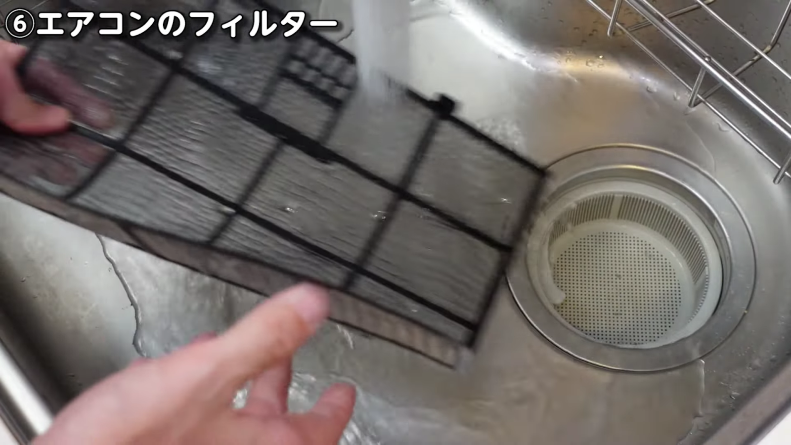 エアコンのフィルターを洗う男性