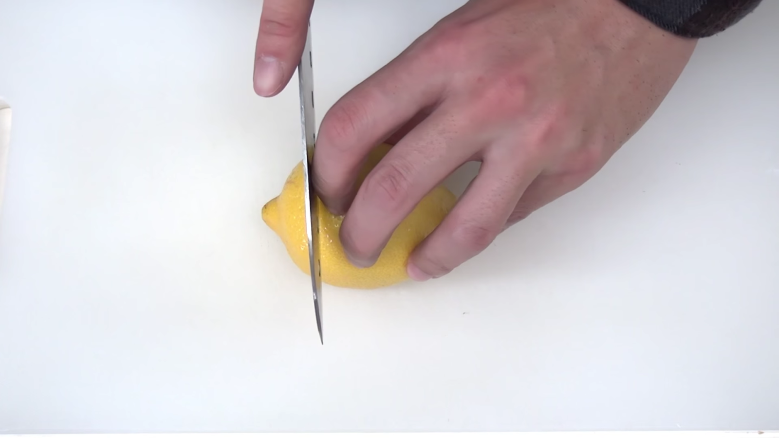包丁でレモンを切る男性
