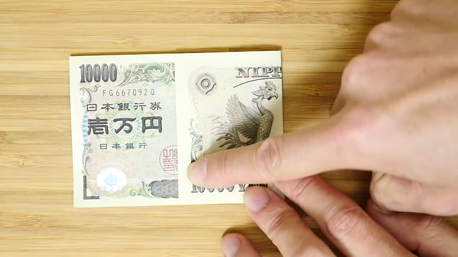 一万円札を折る男性