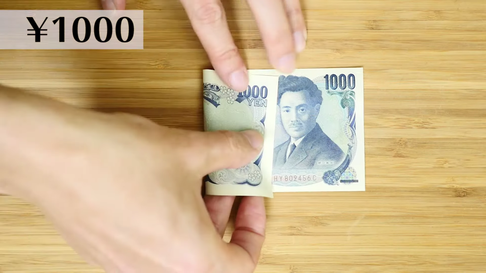 千円札を折る男性