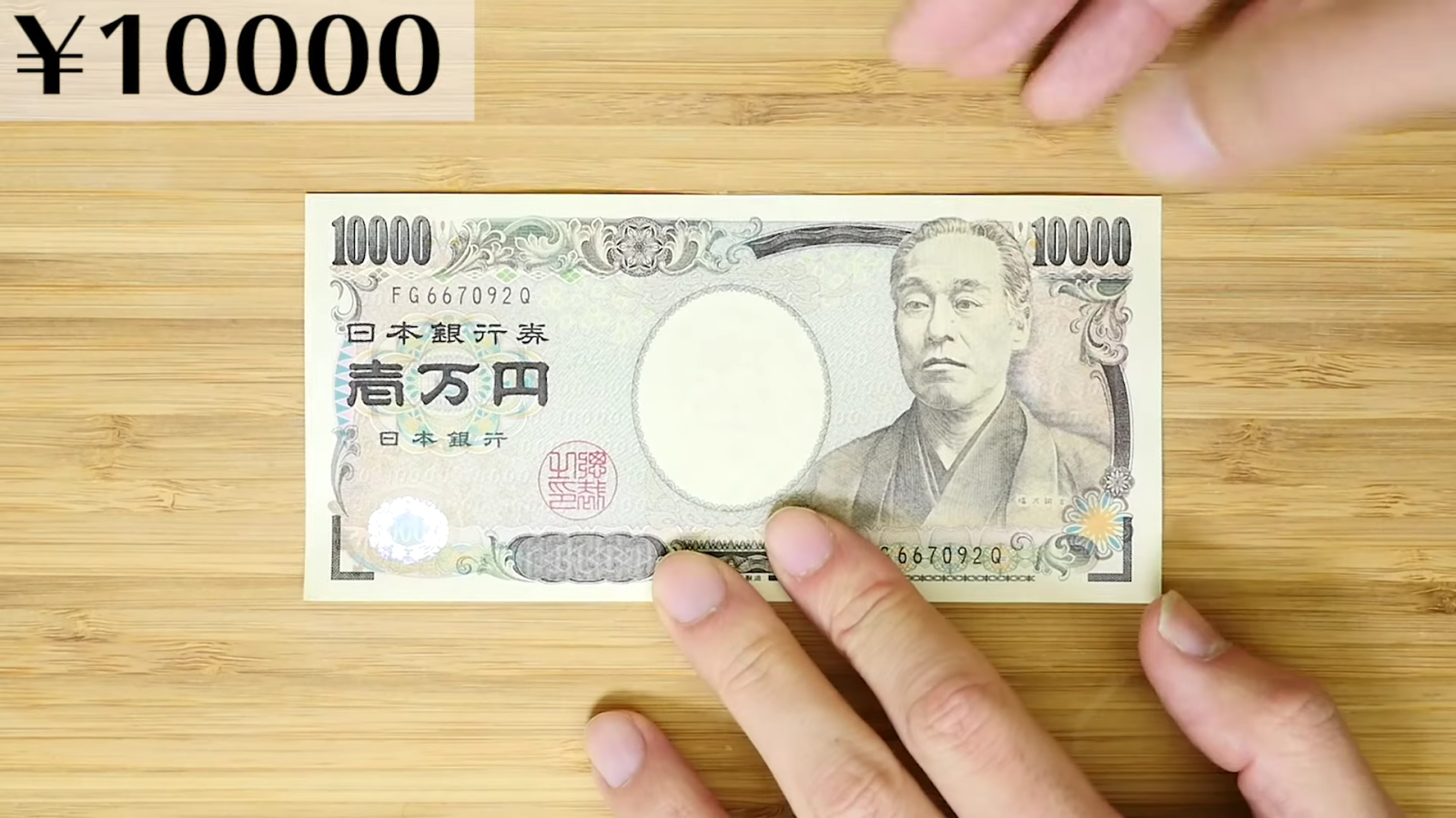 一万円を三つ折りにする男性
