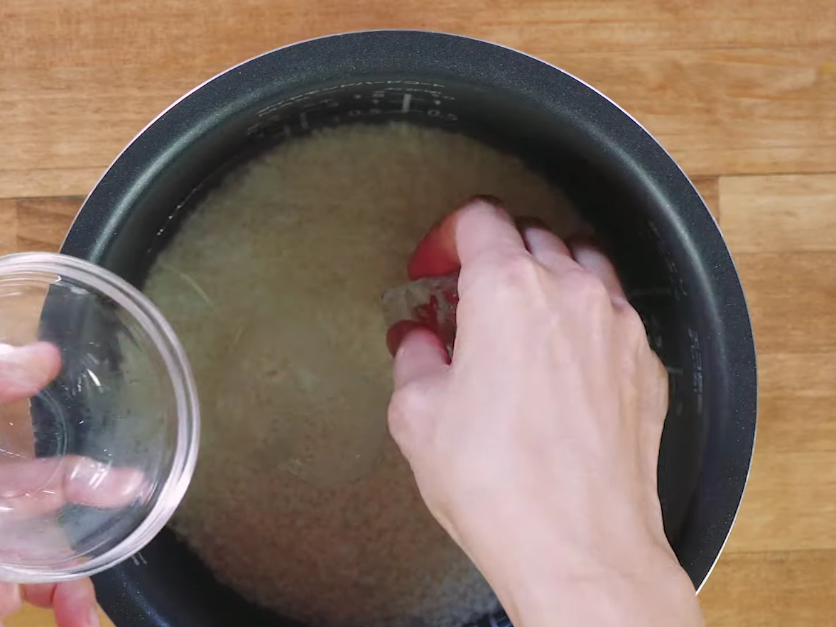炊飯器の釜に氷を入れる女性