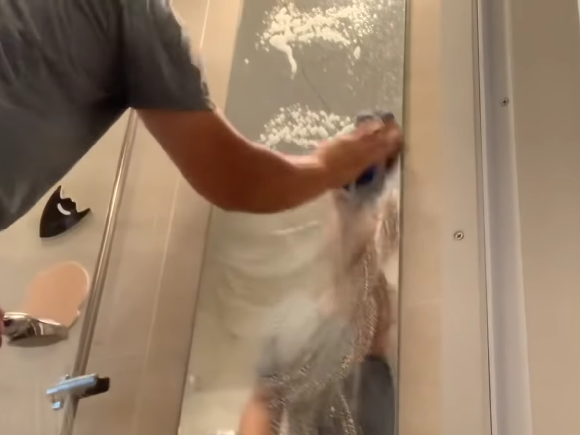 鏡を予洗いする男性