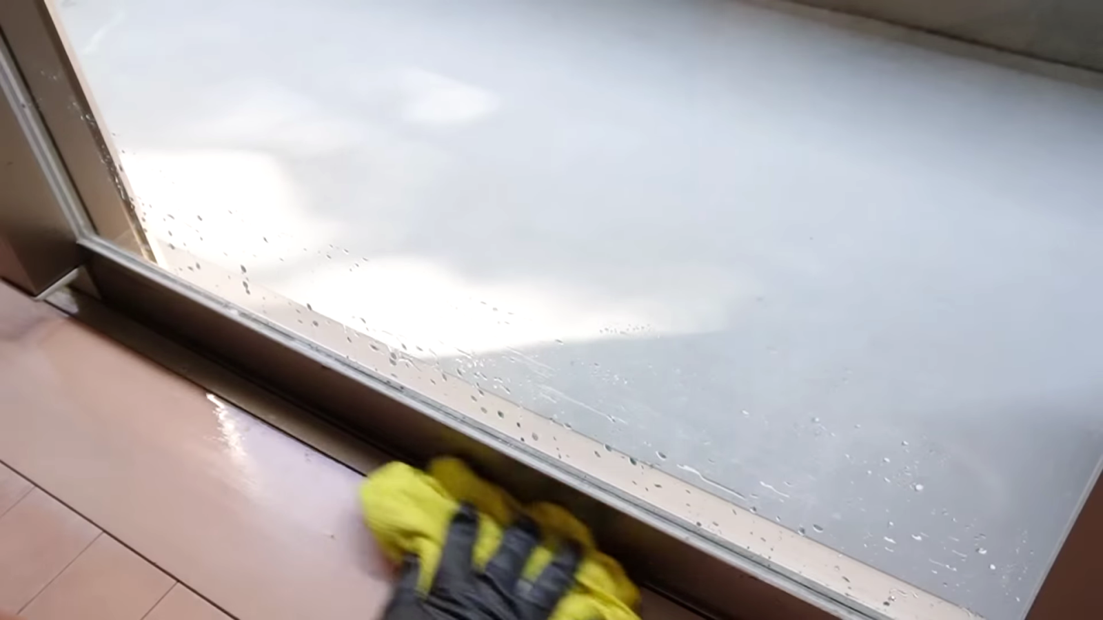窓のゴムパッキンを掃除する男性