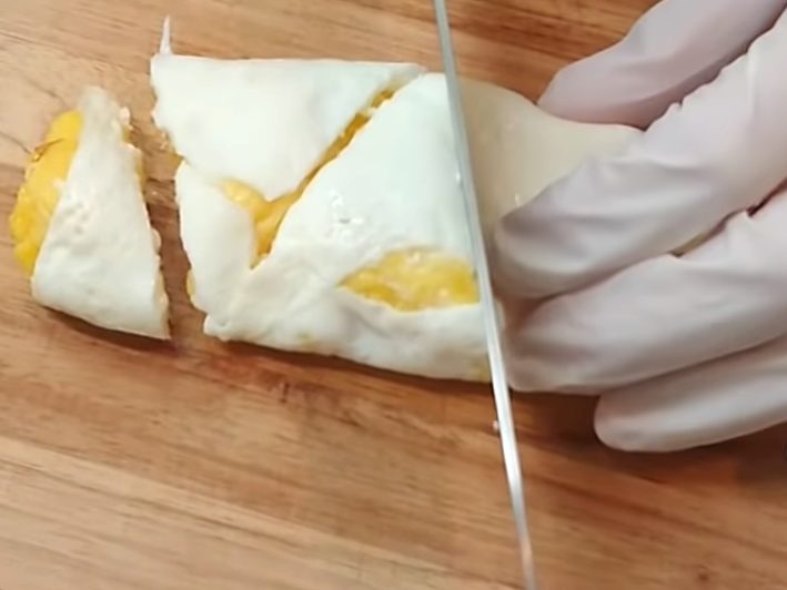 卵焼きを包丁で切る女性