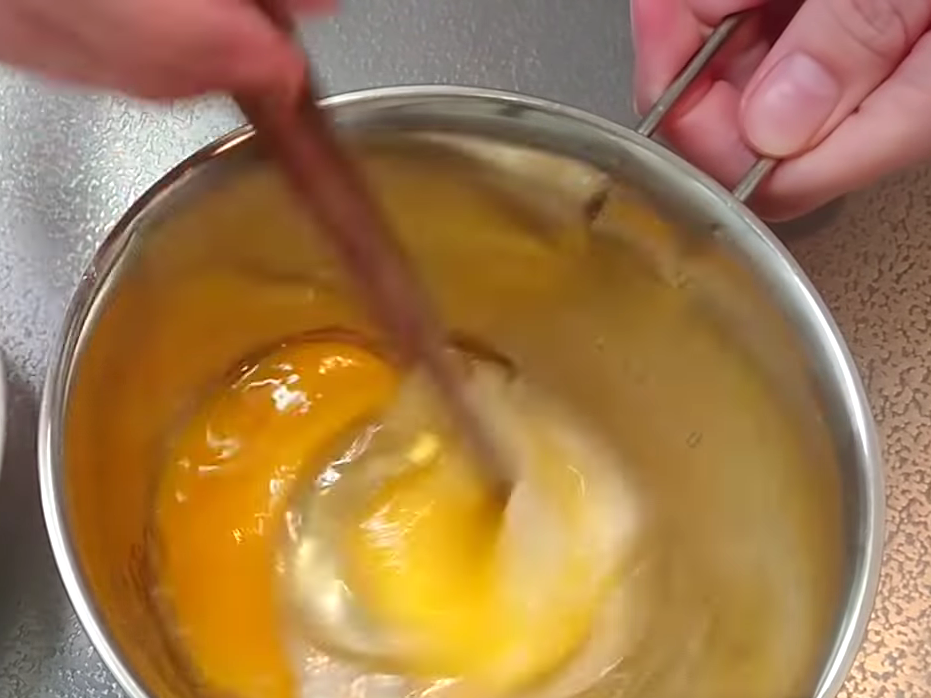 卵黄に味つけをする女性
