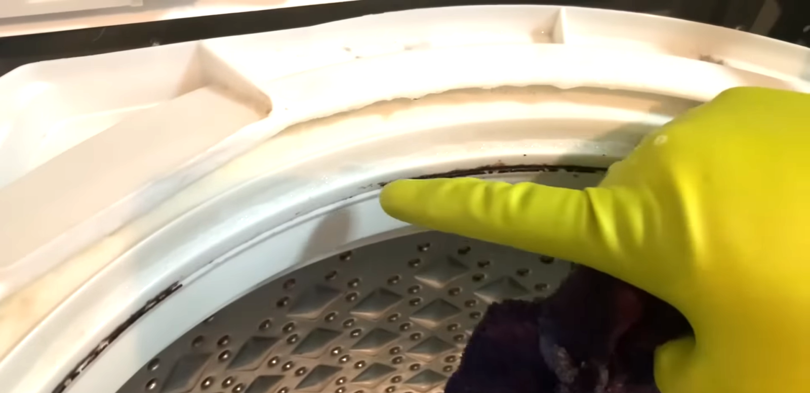 洗濯機についた水垢を取る男性