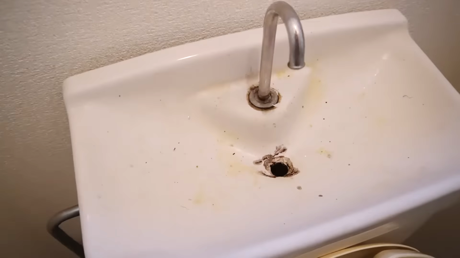 汚れがついたトイレ上のタンクの手洗い場