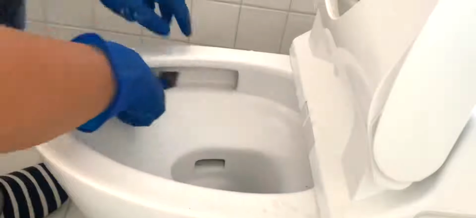 メッシュやすりでトイレ掃除をする男性