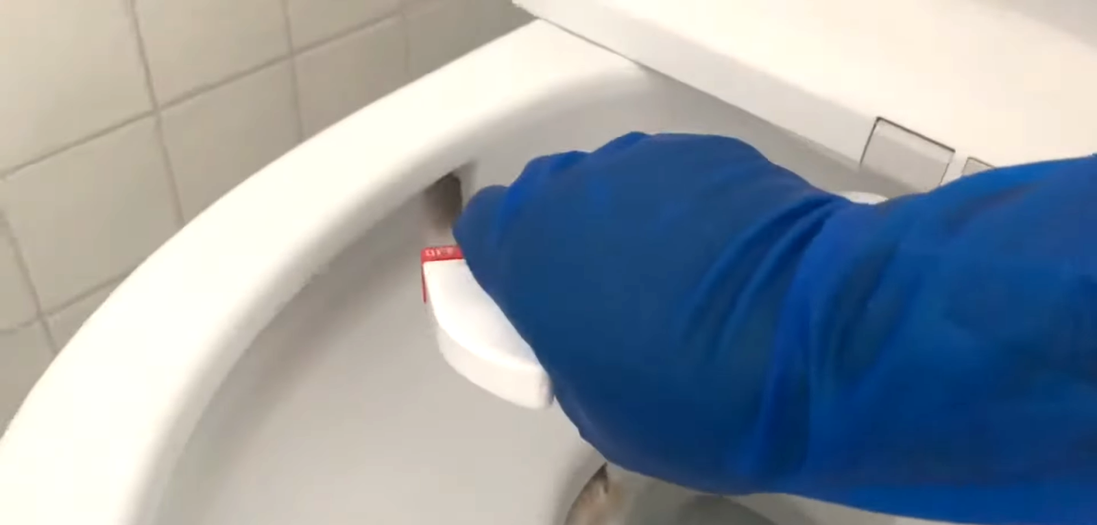 酸性洗剤でトイレの尿石を取る男性