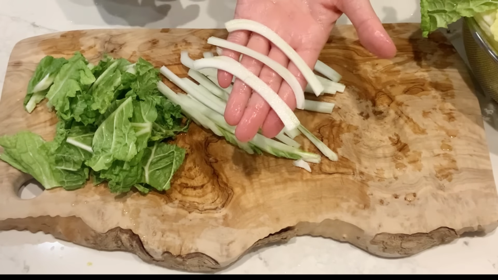 白菜の葉と芯を包丁で切る女性