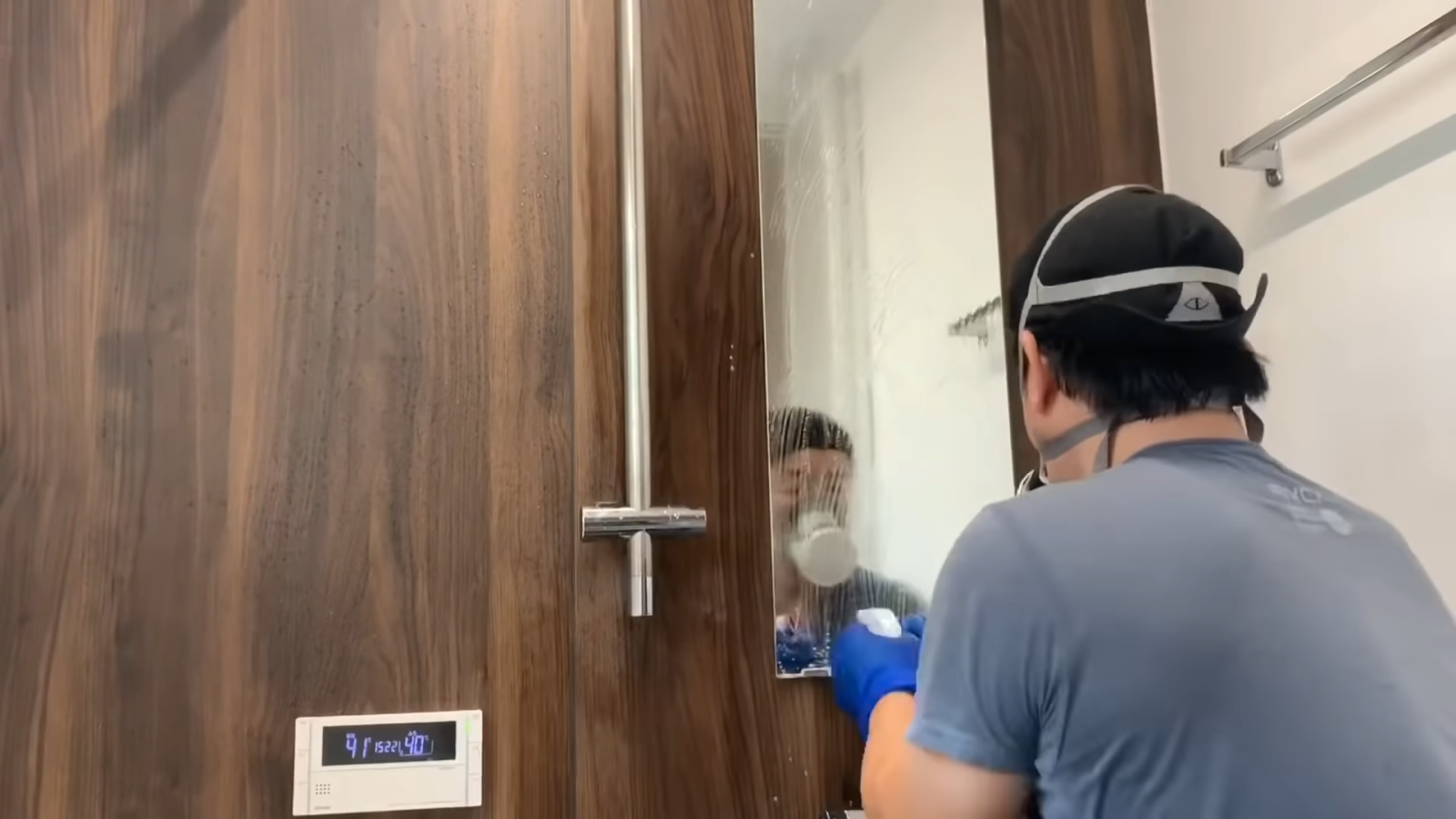 浴室の鏡を掃除する男性