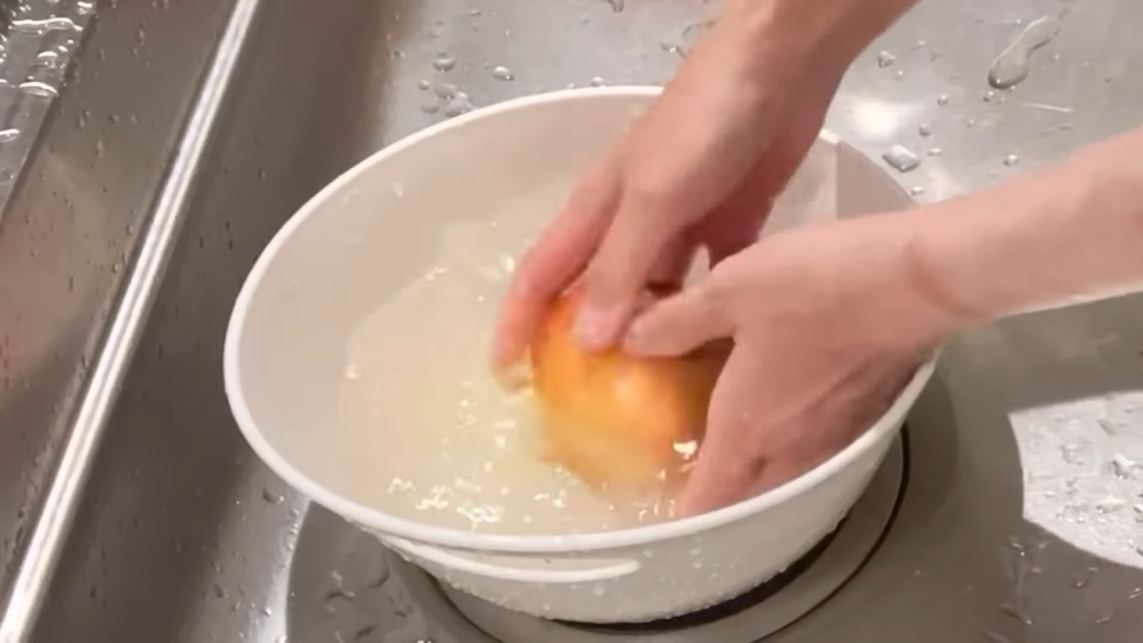 りんごや玉ねぎを洗う女性