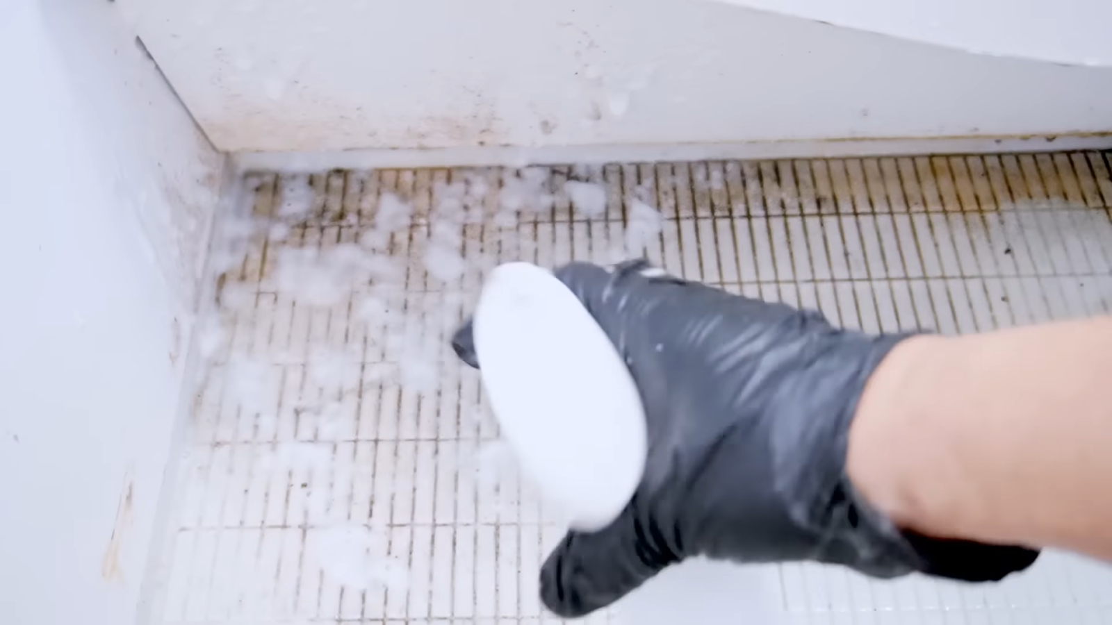 洗面台の下についたカビ汚れを落とす男性