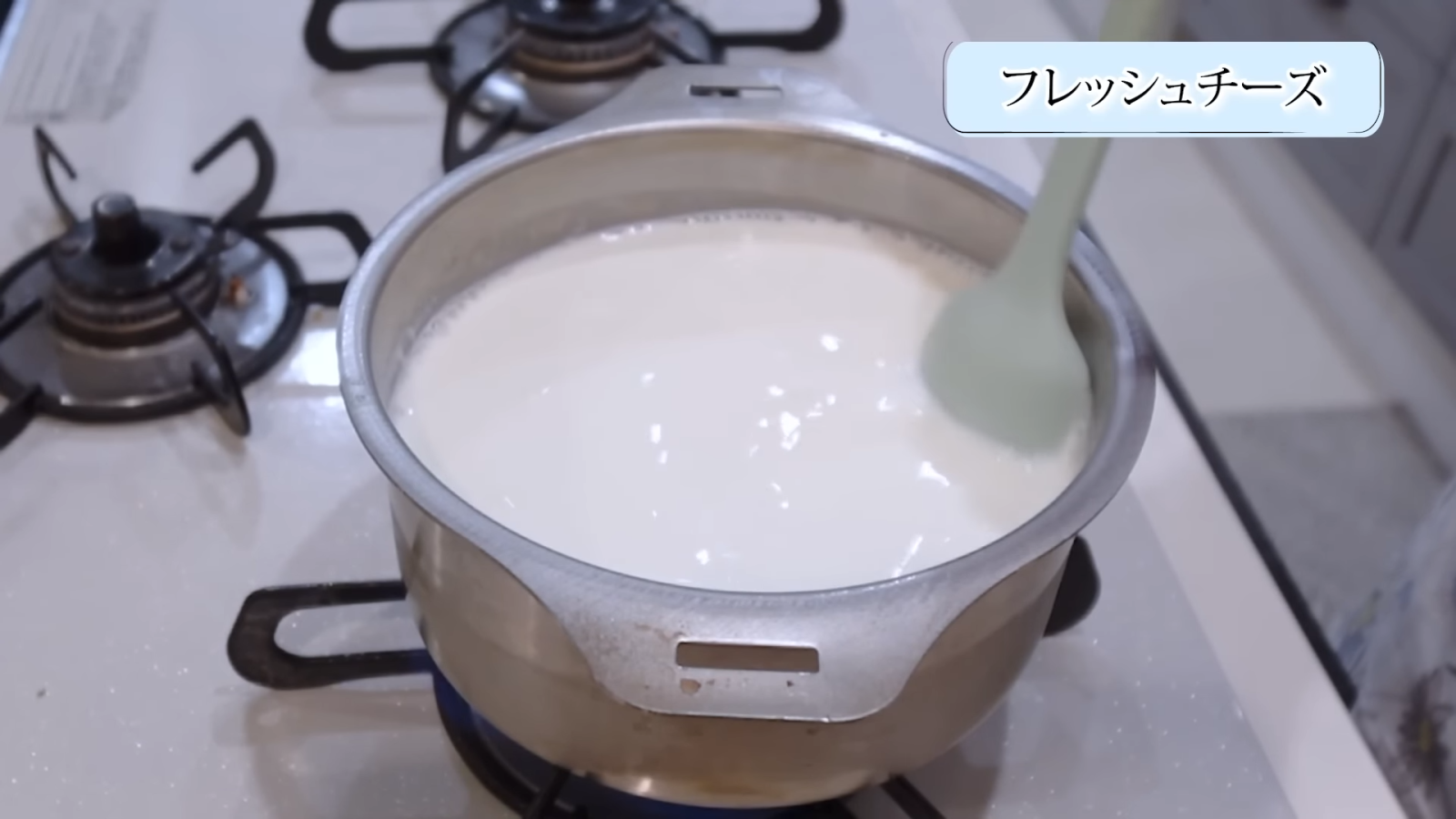 鍋で牛乳とプレーンヨーグルトを混ぜ合わせる女性