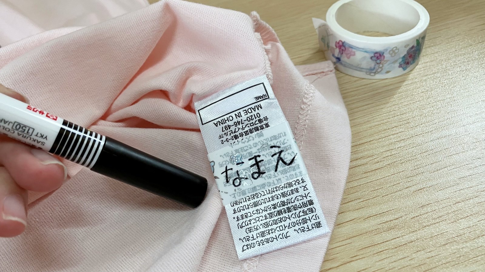 洋服のタグに巻いたマスキングテープに名前を書いた様子