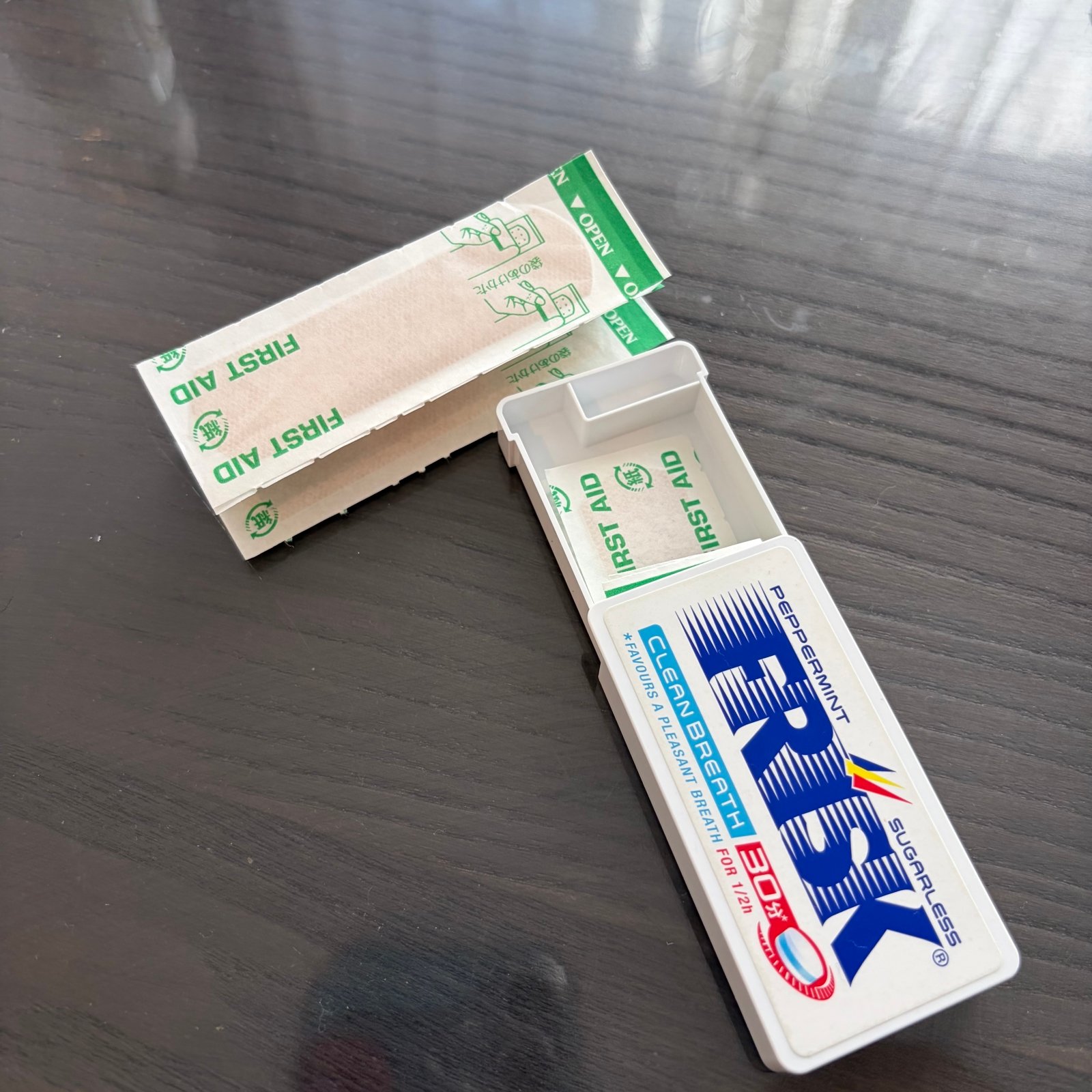 フリスクの空き容器にばんそうこうを入れているところ