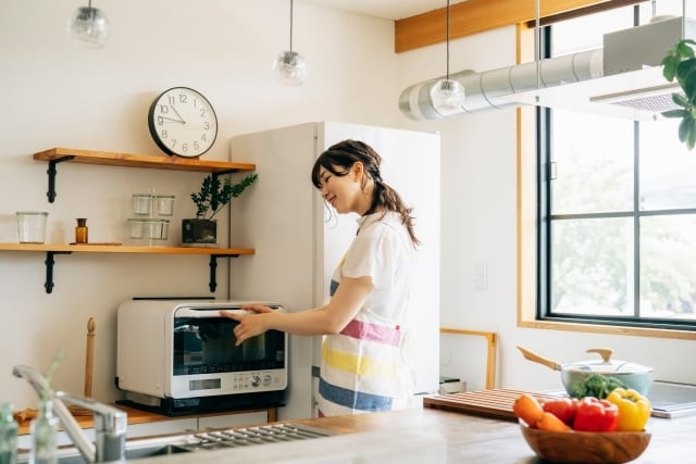 電子レンジを使う女性