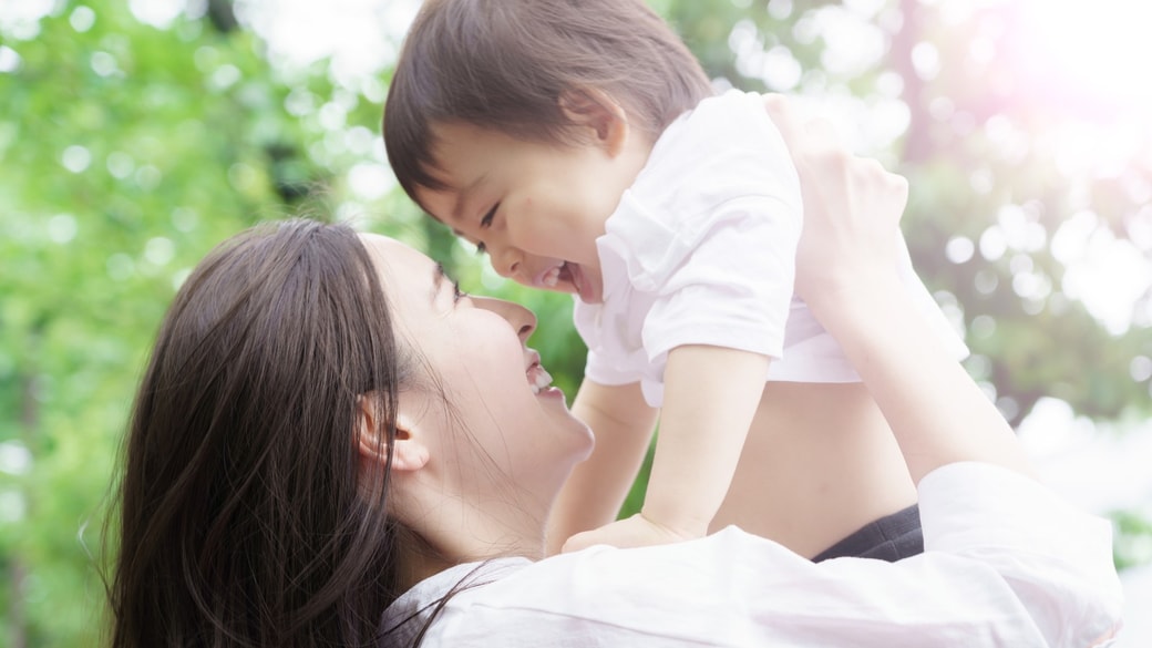 子どもを抱っこする笑顔の母親と子ども