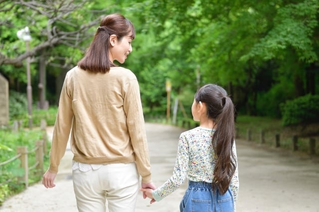 手をつないで歩く親子