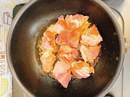 フライパンにごま油をひいて鶏モモ肉を炒める人