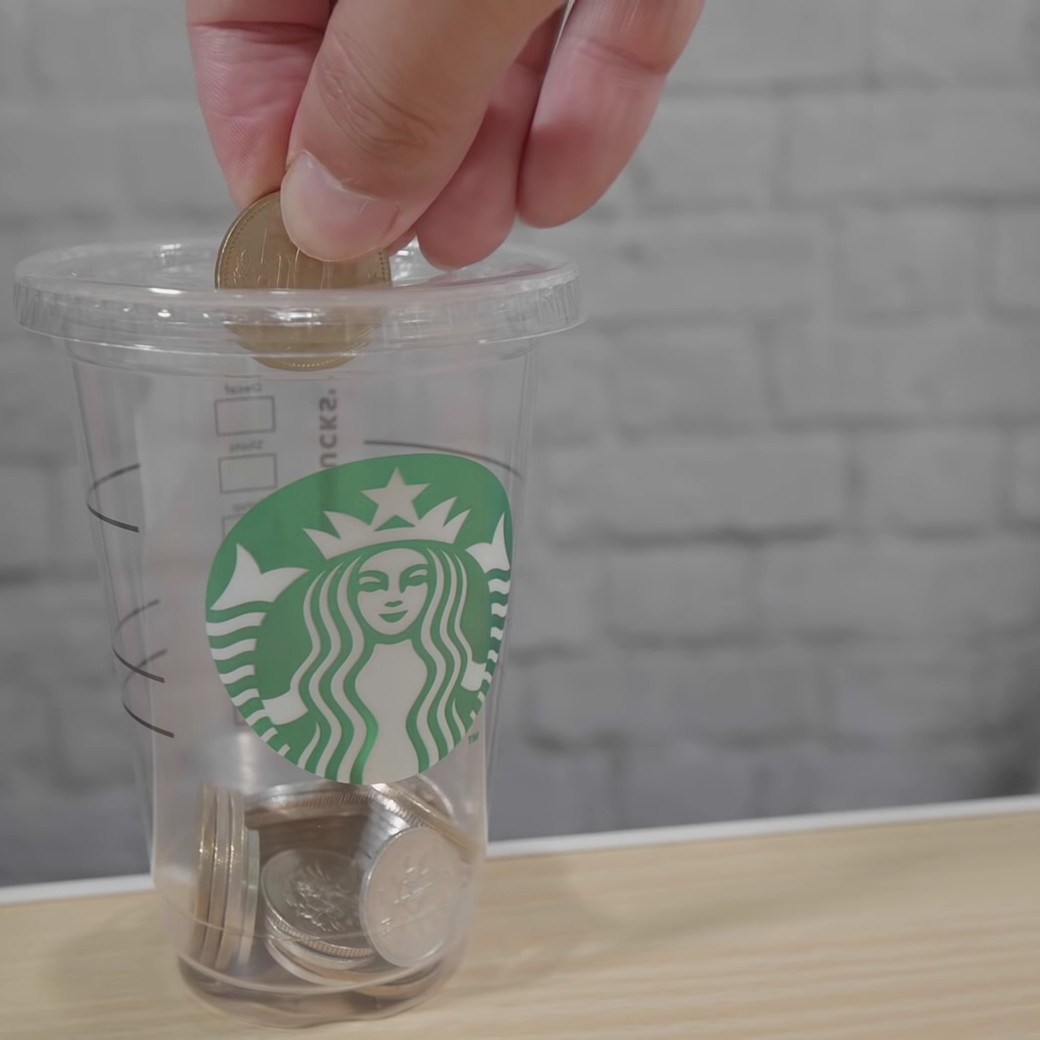 スタバのカップを貯金箱として再利用する男性