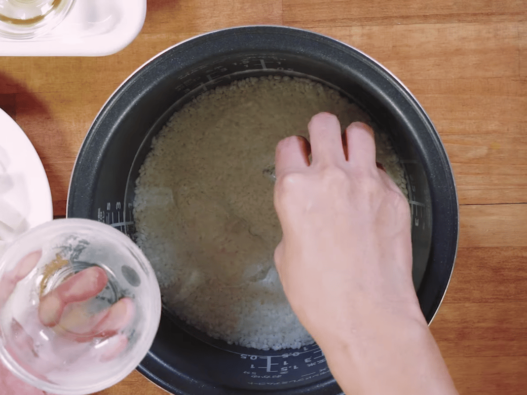 炊飯器に氷を入れる女性