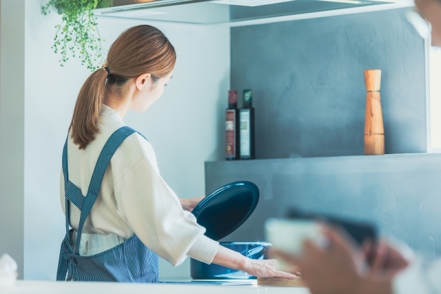 鍋に火をかける女性