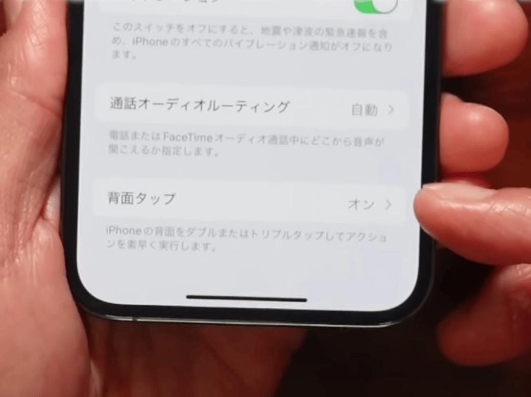 スマホの背面タップを設定する男性