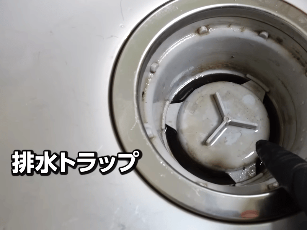 排水トラップを指差す男性