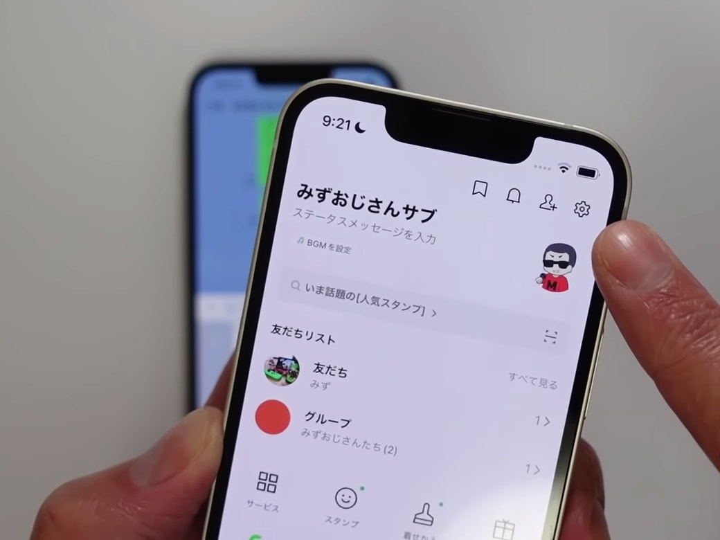 LINEの歯車マークを指差す男性