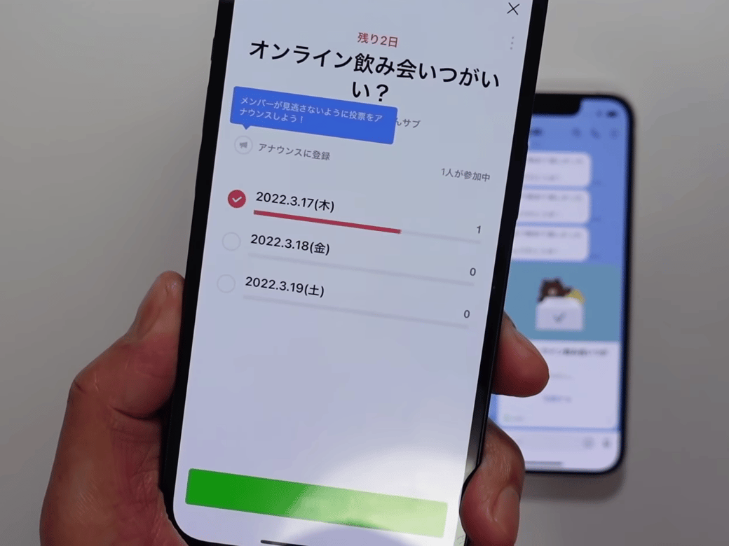 LINEの投票画面を表示している男性