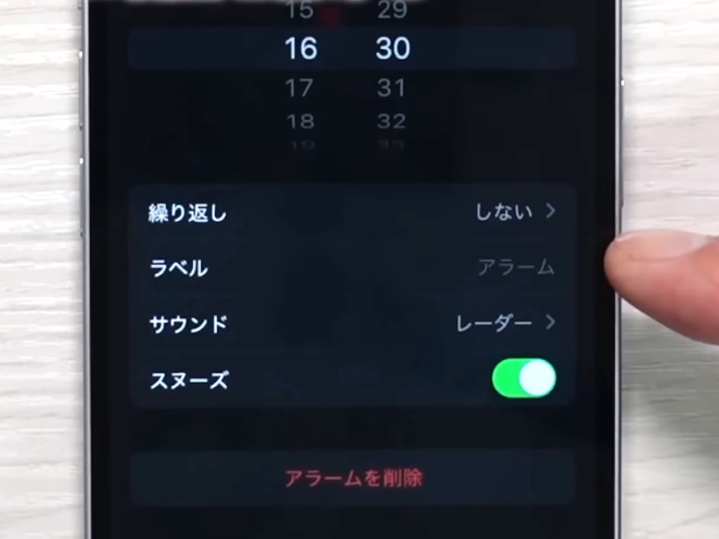 iPhoneでアラームを設定する男性