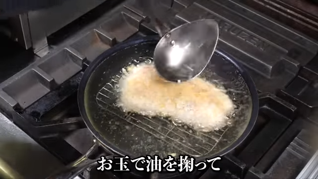 お玉で油をかける