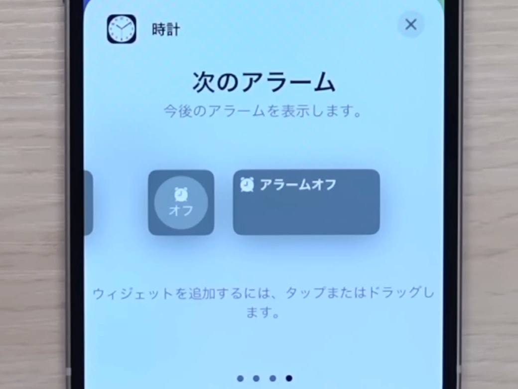 iPhoneから次のアラームの設定をする男性