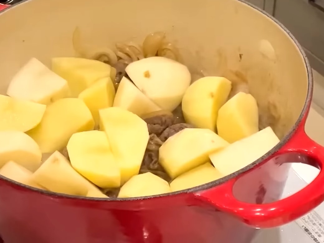 鍋で肉じゃがを作る女性