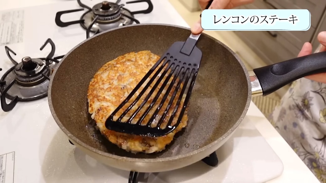 フライパンでれんこんステーキを焼く女性