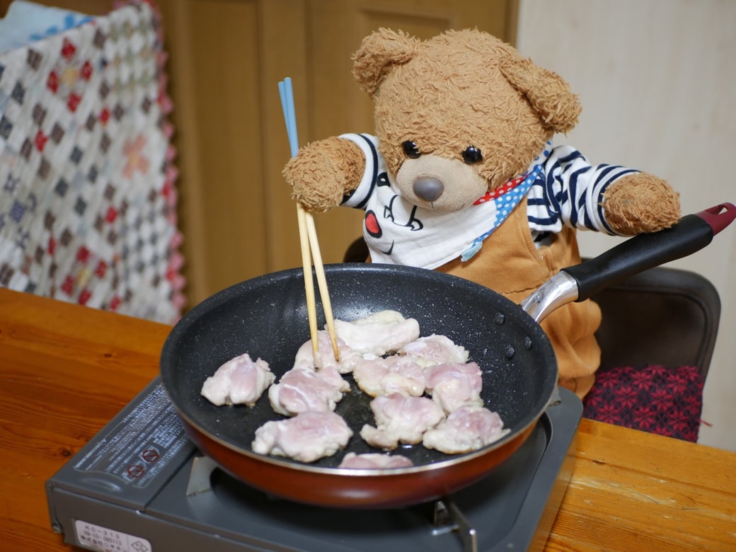 鶏肉を焼き始めるくまくん