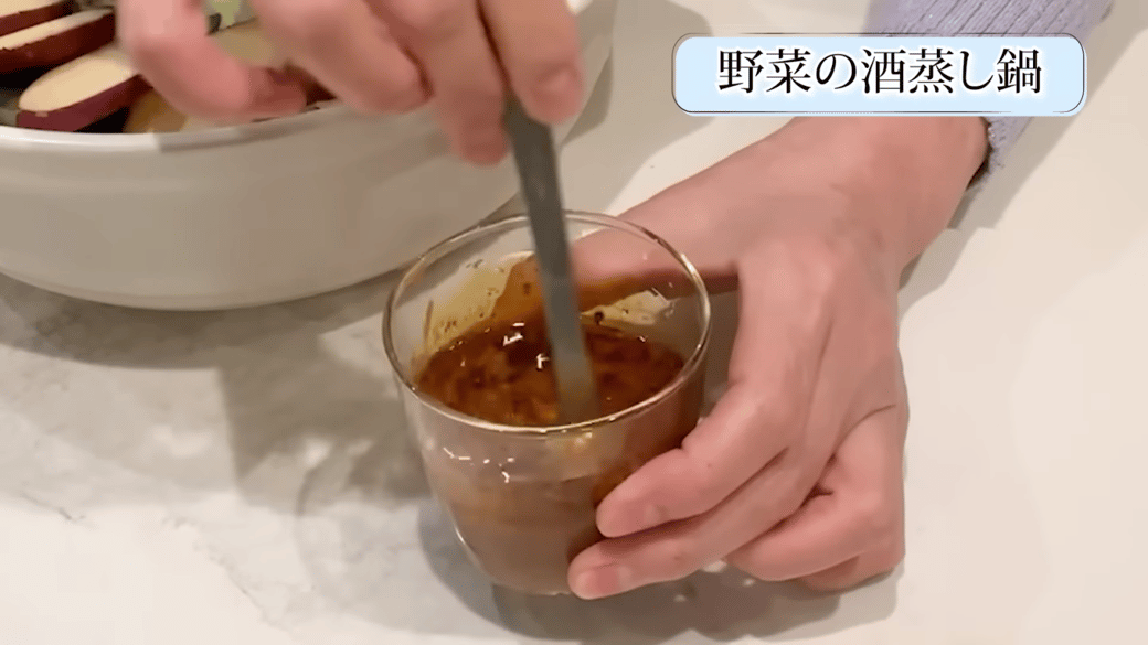 カップで調味料を混ぜる女性