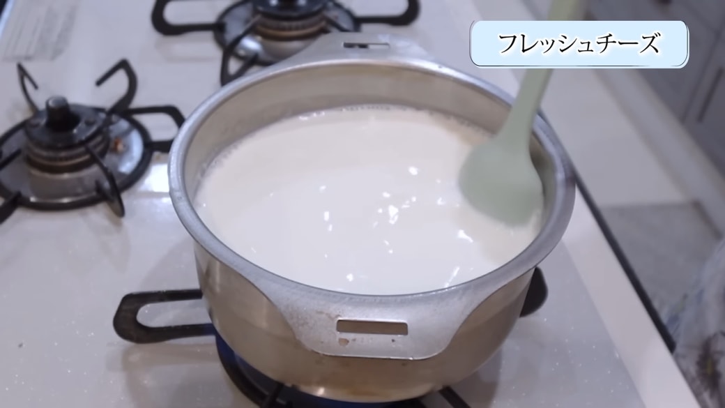 鍋で牛乳とプレーンヨーグルトを混ぜ合わせる女性