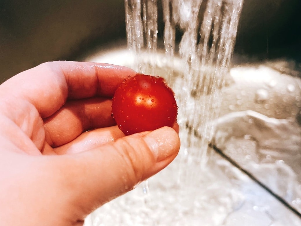ミニトマトをひとつずつ流水で洗う