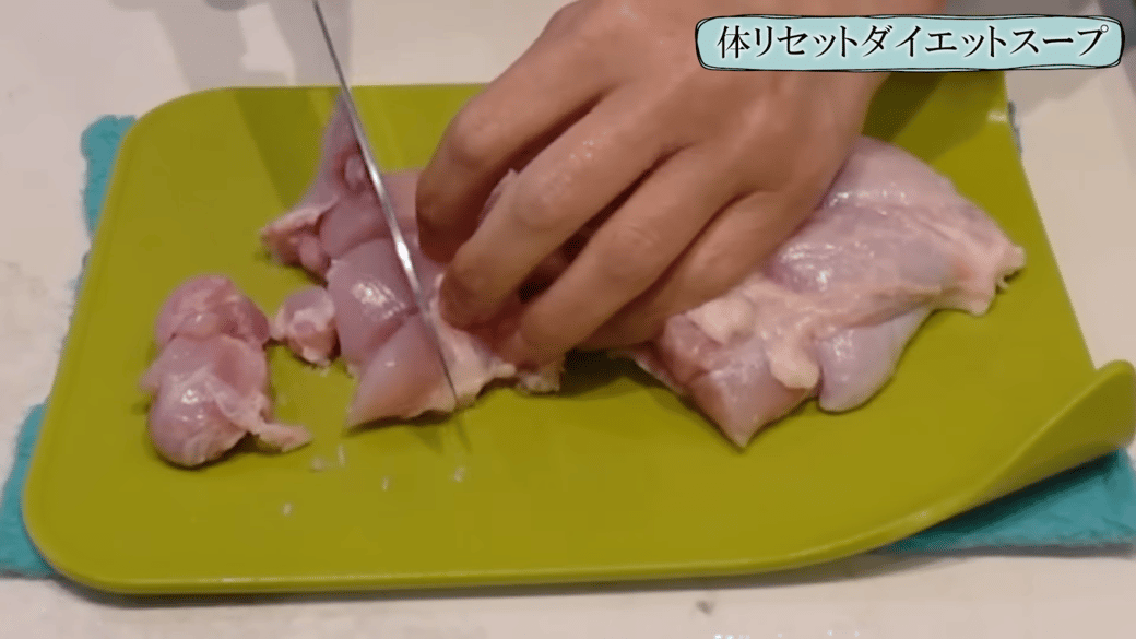 鶏もも肉をひと口大に切る女性