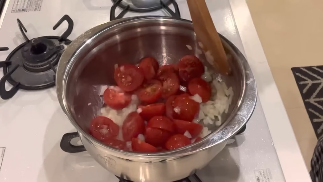 みじん切りの玉ねぎとひと口大のミニトマトが入った鍋