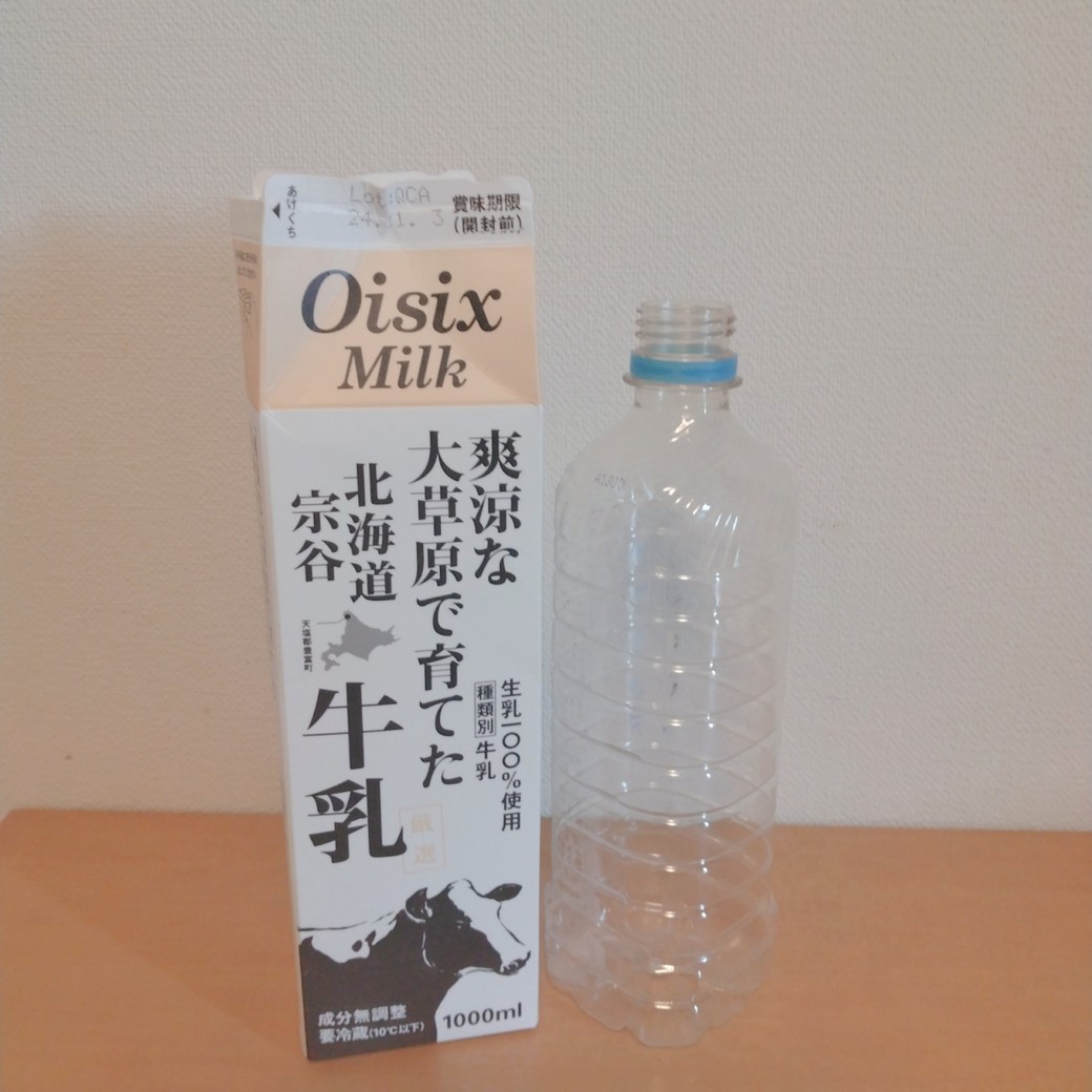 机の上に置いたペットボトルと牛乳パック