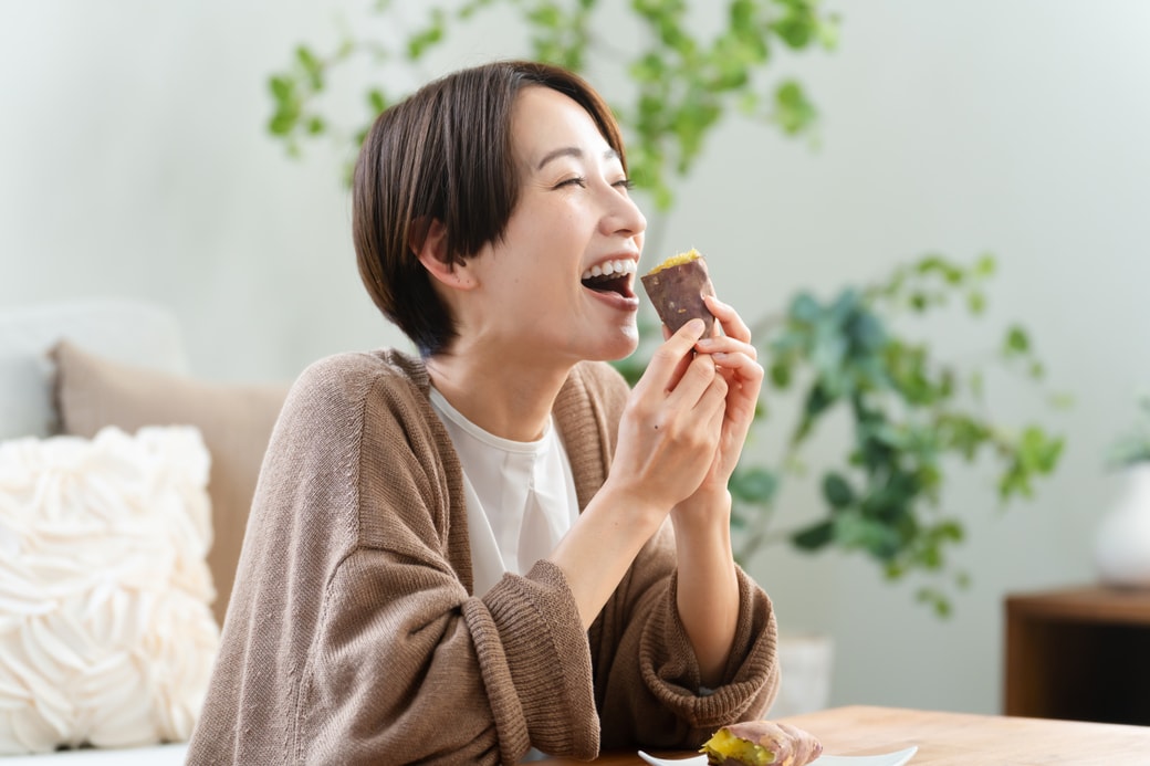 焼き芋を食べる女性