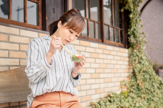 サラダを嫌そうに食べる女性