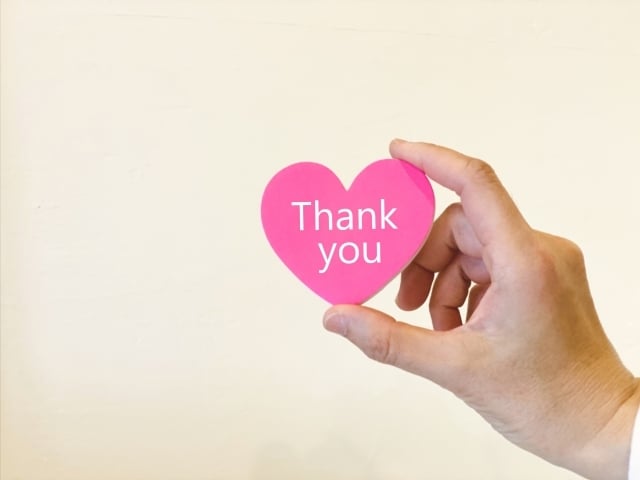 「thank you」と書かれたハートを持つ手