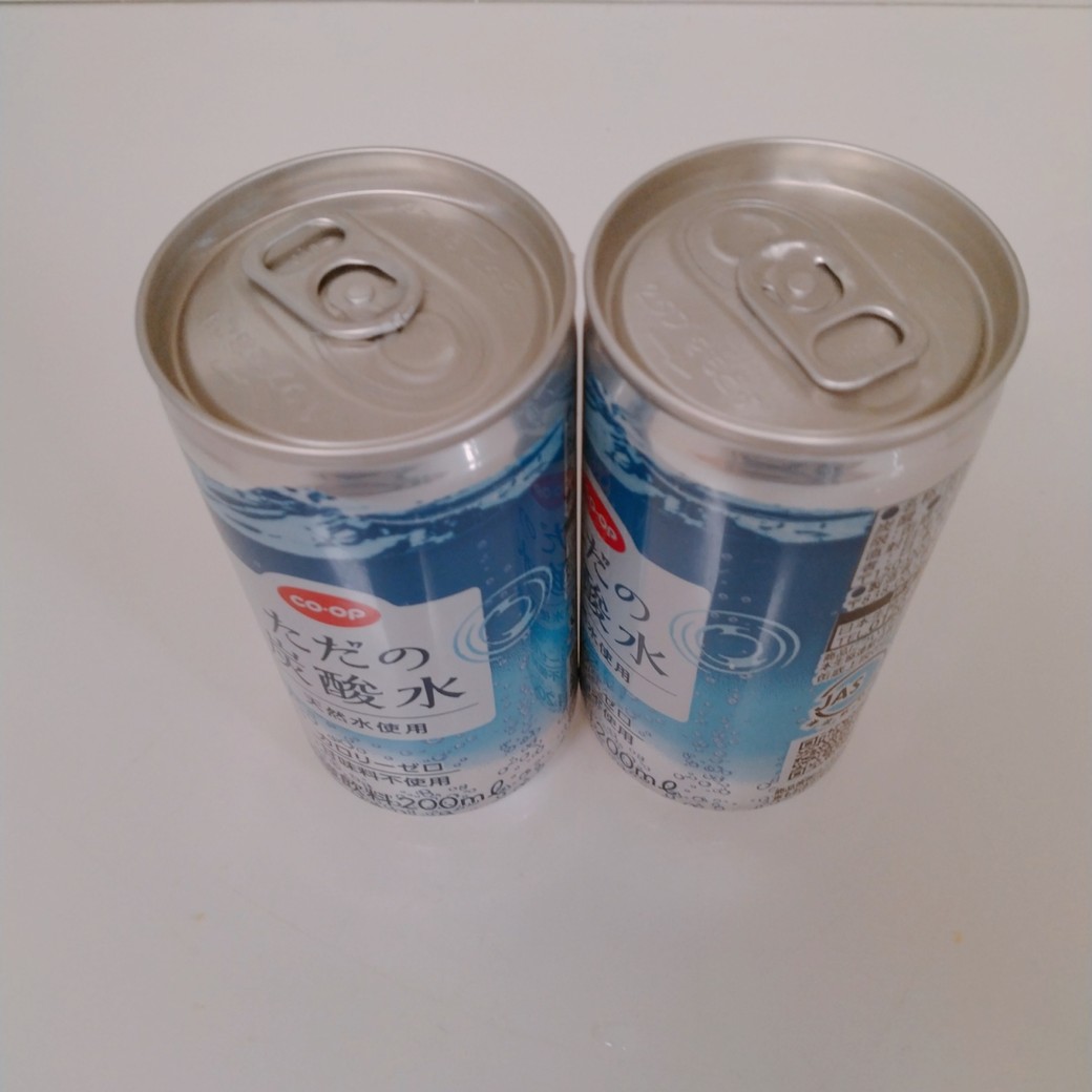 机の上に置いた缶に入った炭酸水